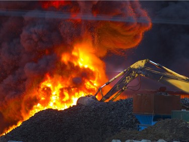 Firefighters appear small in the foreground of this huge fire at Shercom Industries north of Saskatoon, April 4, 2016.