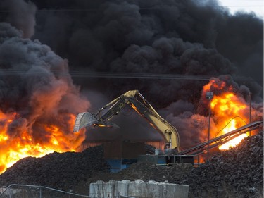 Firefighters appear small in the foreground of this huge fire at Shercom Industries north of Saskatoon, April 4, 2016.