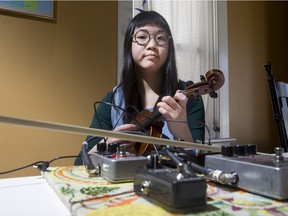 Melissa Gan, who goes by the name respectfulchild while playing music, sits for a photograph with her violin and effects pedals at her home on Saturday, March 26th, 2016.