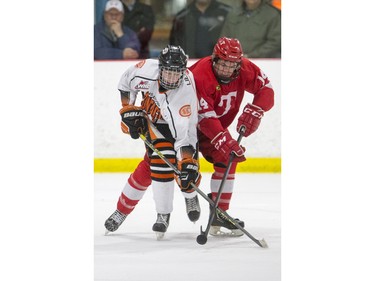 Saskatoon Contacts forward Eli Lieffers battles for the puck with Kenora Thistles defensemen Jarod Price during the Telus Cup regional opener game at Rod Hamm Memorial Arena in Saskatoon, March 31, 2016.