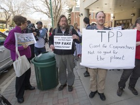 Protesters from Climate Justice Saskatoon and the local Council of Canadians set up placards outside the venue of TPP consultations Wednesday.