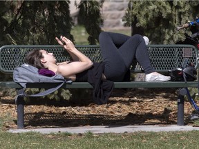 SASKATOON,SK-- April 28/2016  0429 news weather --- Rebecca Zakreski enjoys the sunshine on a bench with some phone reading in Friendship Park, Thursday, April 28, 2016. (GREG PENDER/STAR PHOENIX)