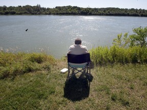 SASKATOON,SK--AUGUST 25/2010-- Margarita Tarnavsky enjoys a good book and some sunshine on the South Saskatchewan River while husband Nick Tarnavsky was fishing below her Wednesday, August 25, 2010. (GREG PENDER/STAR PHOENIX)