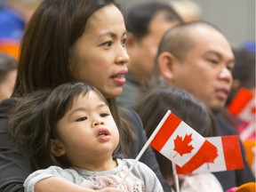 Michele Melimas of Lloydminster, originally from the Philippines, holding two-year-old daughter Brooke, was among those who were sworn in as Canadians in a citizenship ceremony in February in Saskatoon.