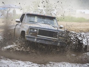 A truck is driven through a mud pit on the flats at Stave Lake near Maple Ridge, B.C. (Ric Ernst / Postmedia News)