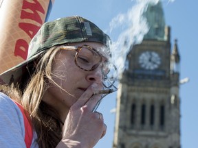 A woman smokes a joint during the annual 420 marijuana rally on Parliament hill on Wednesday, April 20, 2016 in Ottawa. THE CANADIAN PRESS/Justin Tang ORG XMIT: JDT110 ORG XMIT: POS1604201623020242