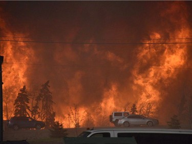 A wall of fire rages outside of Fort McMurray, Alberta, May 3, 2016. Raging forest fires whipped up by shifting winds sliced through the middle of the remote oilsands hub city of Fort McMurray Tuesday, sending tens of thousands fleeing in both directions and prompting the evacuation of the entire city.