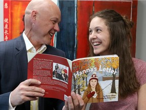 Cancer survivor Darren Ulmer and his daughter Hanna joke with each other as they look at a copy of the new children's book Hanna's Letter. Darren wrote the book, which documents his cancer treatment and his family's methods of coping with his illness.