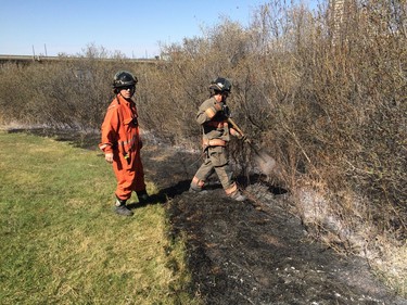 Firefighters worked to put out what remained of a grassfire on the east riverbank between the Broadway and University Bridges in Saskatoon, April 30, 2016.