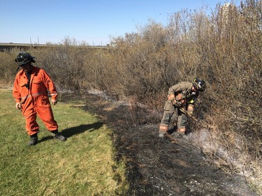 Firefighters worked to put out what remained of a grassfire on the east riverbank between the Broadway and University Bridges in Saskatoon, April 30, 2016.