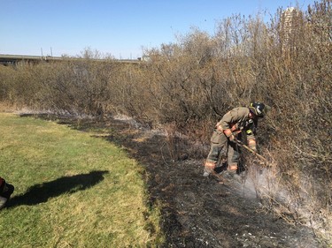 Firefighters worked to put out what remained of a grassfire on the east riverbank between the Broadway and University Bridges in Saskatoon, April 30, 2016.