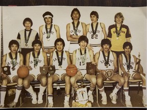 A photograph of the1983 La Loche Basketball team with their trophies and awards from their season; Top row, left to right: Keith Janvier (manager), Lester Janvier, Harold Janvier, Vincent Janvier, Greg Hatch (coach) Bottom row, left to right: Walter Lemaigre, Allistair Lemaigre, Bruce Janvier, Julius Park, Gilbert Lemaigre, Ian Janvier. The photograph of the photo was taken on Tuesday, April 26th, 2016. The La Loche basketball team in 1983, the only La Loche team that has won a provincial basketball title.