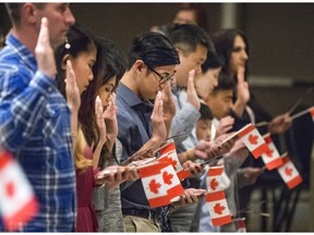 Taking the Oath of Citizenship by raising your right hand is part of the Citizenship ceremony in becoming the newest Canadians in Saskatoon, May 24, 2016.