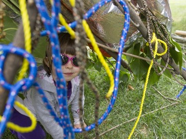 Louise Baker plays in a tent built from sticks and leaves at the Pop-up Playground in Victoria Park, May 28, 2016. This playground is to help children focus on the natural work in Saskatoon.