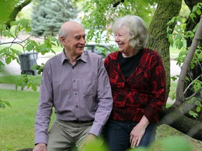 Archeologist Tim Jones and environmentalist Louise Jones sit together on a tree at their home in Saskatoon.