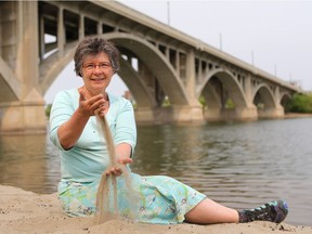NatureCity Festival spokesperson Candace Savage plays with sand by river under the Broadway bridge in Saskatoon on May 18, 2016. The festival's keynote event is 'Water song for a river city'.