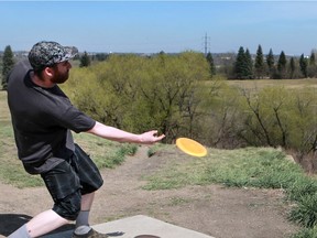 Scott Tigg enjoys a round of disc golf while listening to tunes during a hot spring day at Diefenbaker Park. He has been playing disc golf for five years, appreciates the low cost, and tries to make it out twice a week. (Michelle Berg / Saskatoon StarPhoenix)
