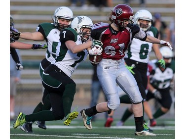 Saskatoon Valkyries' Rienna Rueve steals the ball from Regina Riot's Payton Kuster in women's tackle football action at SMF Field in Saskatoon on May 22, 2016.