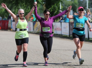 Cheryl Cochrane, Trina Caudle and Karen Toews run to the finish line after completing a half marathon at the Saskatchewan Marathon at Deifenbaker Park in Saskatoon on May 29, 2016.