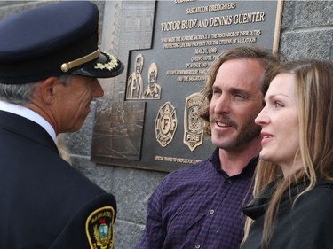 Graham and Sarah Guenter shake hands in front of the plaque honouring Victor Budz and Dennis Guenter who lost their livesfighting a fire at the Queen's Hotel fire May 31, 1980.