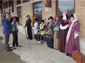 Teacher Marguerite Wiggins, left, speaks with students who were dressed in period costume as a Grade 4/5 split class from Legacy Christian Academy made a field trip stop at the CPR station on Idylwyld Drive to learn about early immigration in Saskatoon, Tuesday, May 10, 2016.