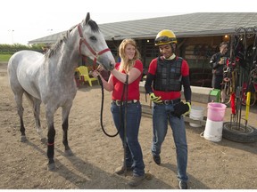 Trainer Jamie Hartmann at work at Marquis Downs with jockey Stanley Chadee and three-year-old Short of Money during an early morning workout.