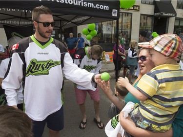 The Saskatchewan Rush of the National Lacrosse League held a noon-hour rally on 21st Street East in Saskatoon, May 20, 2016, in a lead up to their weekend battle with the Calgary Roughnecks. Food trucks and other festivities were featured for fans, as well as an attendance by a number of players. Mark Mathews gives a signed ball away to a fan.