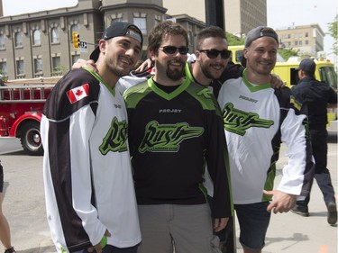 The Saskatchewan Rush of the National Lacrosse League held a noon-hour rally on 21st Street East in Saskatoon, May 20, 2016, in a lead up to their weekend battle with the Calgary Roughnecks. Food trucks and other festivities were featured for fans, as well as an attendance by a number of players. Nic Bilic, Mark Mathews and Adrian Sorichetti pose with a fan.