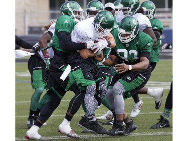 Wide receiver Rob Bagg (C, in white) fights to hold the ball during Saskatchewan Roughriders training camp at Griffiths Stadium, May 30, 2016.