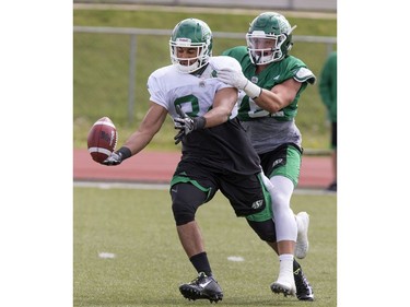 Wide receiver Seydou Haidara is grabbed away from the ball on a pass play by linebacker Dillon Grondon during Saskatchewan Roughriders training camp at Griffiths Stadium, May 30, 2016.