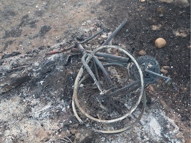 The remains of a charred bicycle sits in a residential neighbourhood on May 6, 2016 in Fort McMurray, Alberta. Wildfires, which are still burning out of control, have forced the evacuation of more than 80,000 residents from the town.