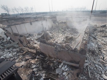 The foundation of a home smoulders in a residential neighbourhood destroyed by a wildfire on May 6, 2016 in Fort McMurray, Alberta. Wildfires, which are still burning out of control, have forced the evacuation of more than 80,000 residents from the town.