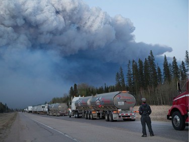 Drivers wait for clearance to take firefighting supplies into town on May 5, 2016 outside of Fort McMurray, Alberta. Wildfires, which are still burning out of control, have forced the evacuation of more than 80,000 residents from the town.