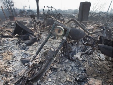 The remains of a charred motorcycle sit in a residential neighbourhood destroyed by a wildfire on May 6, 2016 in Fort McMurray, Alberta. Wildfires, which are still burning out of control, have forced the evacuation of more than 80,000 residents from the town.