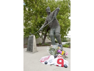 A collection of flowers, pucks and jerseys at the Gordie Howe statue outside of Sasktel Centre in Saskatoon, June 10, 2016. Howe passed away today at the age of 88.