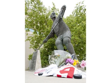 A collection of flowers, pucks and jerseys at the Gordie Howe statue outside of Sasktel Centre in Saskatoon, June 10, 2016. Howe passed away today at the age of 88.