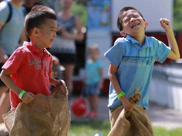 Evan and Steven Qiu are all smiles during the potato bag race at the PotashCorp Children's Festival at Kiwanis Park Sunday in Saskatoon.