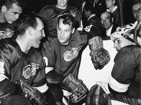 In this Oct. 27, 1963, file photo, Detroit Red Wings star forward Gordie Howe is surrounded by teammates as he kneels after scoring his 544th goal to tie the National Hockey League all-time record, in Detroit. From left are Larry Jeffrey, Bill Gadsby, Howe, and Terry Sawchuck. Behind Howe is Alex Faulkner.