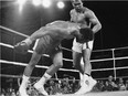 FILE - In this Oct. 30, 1974, file photo, challenger Muhammad Ali watches as defending world champion George Foreman goes down to the canvas in the eighth round of their WBA/WBC championship match in Kinshasa, Zaire. Ali, the magnificent heavyweight champion whose fast fists and irrepressible personality transcended sports and captivated the world, has died according to a statement released by his family Friday, June 3, 2016. He was 74.