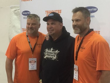 Garth Brooks (C) stands with former NHLers Kelly Chase (L) and Curtis Leschyshyn at Brook's ProCamps ball hockey clinic for Saskatoon youth on June 11, 2016.