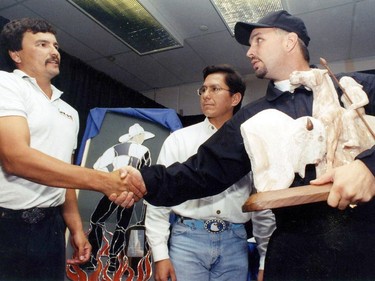 Garth Brooks receives a sculpture from FSIN's Blaine Favel (C) and a stained glass piece from Sask Place, August 14, 1996.