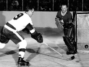 Gordie Howe (left) and Johnny Bower in one of their many NHL skirmishes.