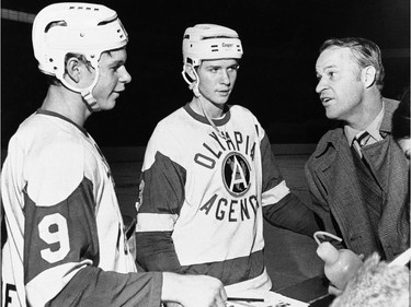 Gordie Howe talks to his two sons, Mark, 15 (L), and Marty, 16, before a game at Olympia Stadium in Detroit on January 29, 1971.
