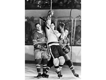 Detroit Red Wings Gordie Howe (C) is sandwiched between Montreal Canadiens, Butch Bouchard (L) and Floyd Curry in this 1955 photo in Detroit during the the Stanley Cup finals.
