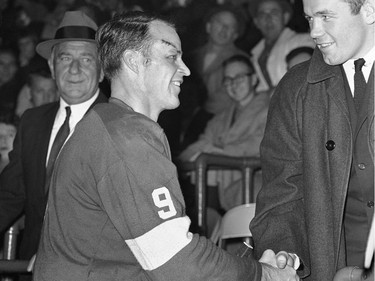 World heavyweight champion Ingemar Johansson (R) shakes hands with Detroit Red Wings' Gordie Howe between periods of the Detroit-Toronto hockey game, January 18, 1960 in Detroit.