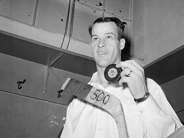 Gordie Howe of the Detroit Red Wings poses with the hockey puck in the dressing room at Madison Square Garden after he scored the 500th goal of his National Hockey League career in New York City, March 14, 1962.