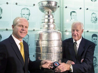 Hockey Hall of Fame inductee Mark Howe (L) poses with his father Gordie Howe beside the Stanley Cup after receiving his ring at the Hall in Toronto on November 14, 2011.