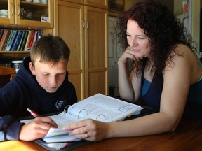 MARTENSVILLE, SK - Melody Yuzik helps her son Shaidon Yuzik with his Grade 5 homework in Martensville, SK on June 16, 2016.