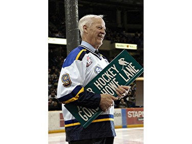 Gordie Howe hangs onto the sign which will adorn the street in front of Credit Union Centre after a presentation there prior to a junior hockey game between the Saskatoon Blades and the Prince Albert Raiders, February 25, 2005.