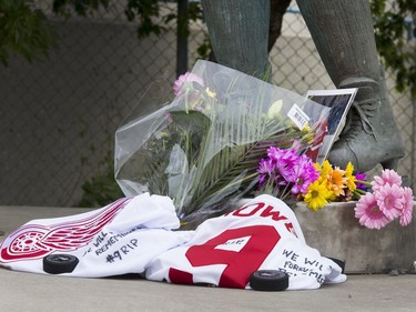 Flowers, jerseys, pucks and pictures lay next to the skates of the statue of Gordie Howe at SaskTel Centre in Saskatoon, June 10, 2016.